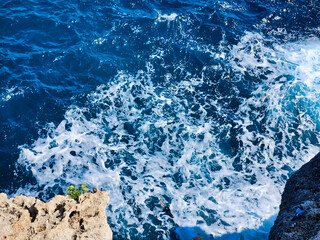 Fototapeta premium Aerial view of wave pattern. Beautiful abstract background of blue water with waves and splashes. Aerial view of the ocean water surface and waves. Blue water of ocean. Blue sea and a moving.