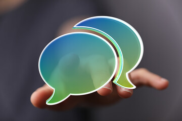 Abstract image of two speech bubbles in a hand, representing communication and conversation.