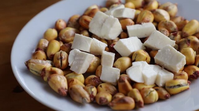 Cancha serrana servida con trozos de queso fresco