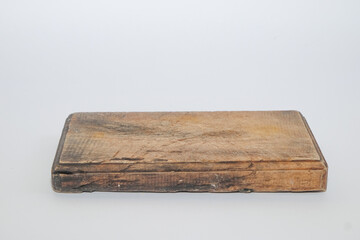 Fototapeta premium Close up of rustic used wooden cutting board isolated on white background. Worn kitchen surface with scratches and grain texture. Ideal for cooking, food preparation, and kitchenware concepts