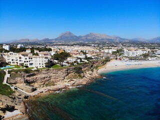 Beach town El Albir in Alfaz del Pi municipality of Alicante Province, Valencian Community in Spain. Costa Blanca region holiday town. Drone point of view in April.