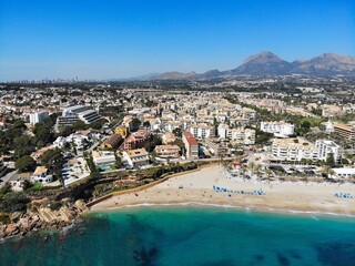 Fototapeta premium Beach town El Albir in Alfaz del Pi municipality of Alicante Province, Valencian Community in Spain. Costa Blanca region holiday town. Drone point of view in April.