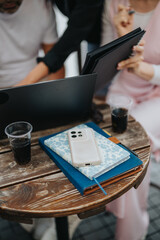 Casual business meeting with a diverse team exchanging ideas, utilizing laptops and tablets in a relaxed cafe setting. Vibrant atmosphere highlights creative teamwork and engagement.