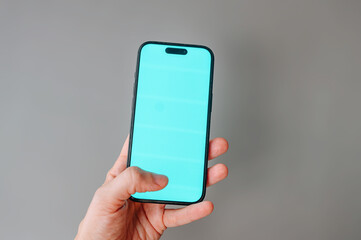 A hand holding a smartphone with a clean, blank screen for a mockup