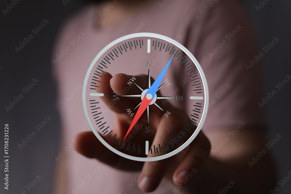 Poster close-up of a hand interacting with a digital compass interface. find your direction.