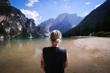 Mujer en lago italiano viendo las montañas