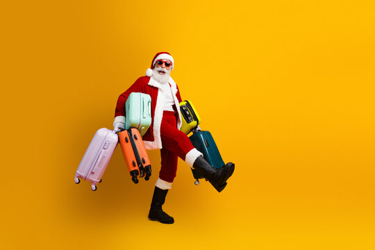 Santa Claus joyfully carrying colorful luggage against a bright yellow background, showing festive holiday travel spirit