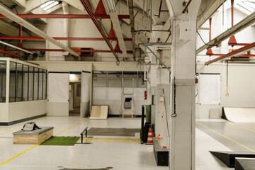 Spacious warehouse interior with skate ramps, rails, and industrial features. Perfect for urban, sports, and industrial themes.