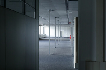 Modern empty office space with grey carpet, white walls, and bright windows. Ideal for commercial real estate.