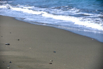Beach with stones, sand and sea edge in Cyprus during summer