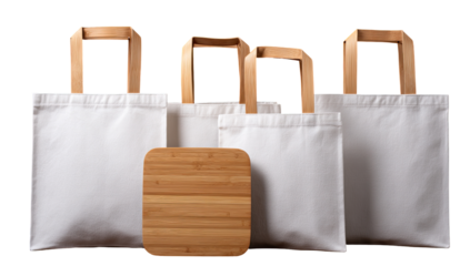 Four blank white tote bags and a bamboo cutting board