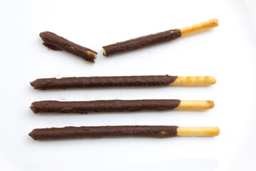 Some chocolate stick biscuits on a white background.