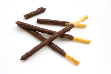 Some chocolate stick biscuits on a white background.