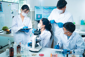 Group of scientists collaborating in a laboratory, engaging in teamwork and planning around experiments, symbolizing cooperation, diversity, and innovation in healthcare and science.