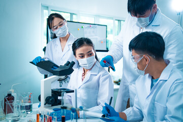 Group of scientists collaborating in a laboratory, engaging in teamwork and planning around experiments, symbolizing cooperation, diversity, and innovation in healthcare and science.
