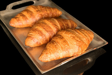 Chocolate croissants isolated on black background, close-up.