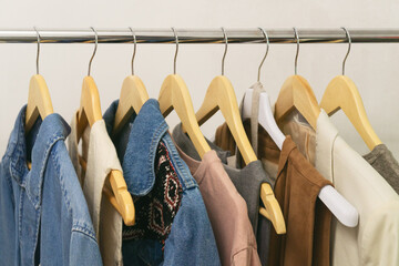 Upcycled fashion collection showcasing second hand denim pieces on wooden hangers. Eco thrifting.