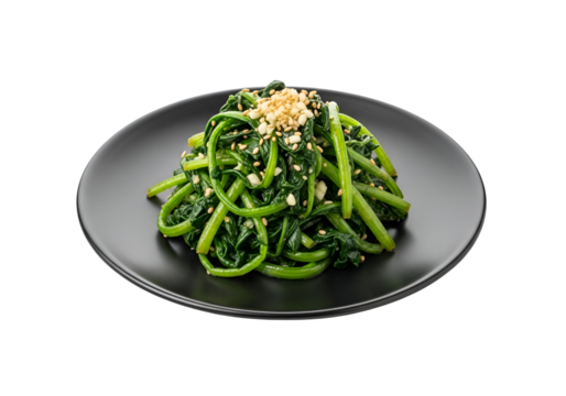 A vibrant heap of saut?ed greens, garnished with sesame seeds and garlic, rests attractively on a dark plate against a stark black backdrop.