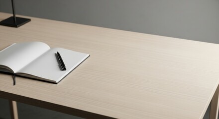 Minimalist workspace with open notebook and pen on light wooden table surface