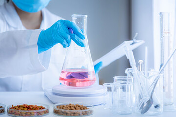 Quality control personnel are weighing dry pet food for inspecting the quality. Quality control process of pet food industry.