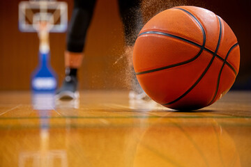 Basketball on Wooden Court with Dust Particles Showing Intensity of the Game