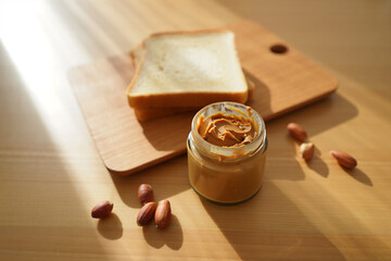 Peanut Butter Delight A Jar of Creamy Goodness with Toast and Scattered Peanuts