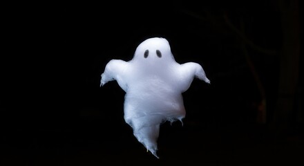 A fluffy, white candy ghost floats against a stark black background, highlighting its ethereal form.
