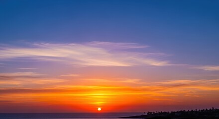 Obraz premium Beautiful Sunset Over Ocean with Colorful Sky and Gentle Waves Reflecting Warm Light