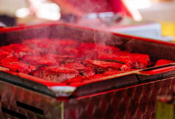 Grilled pork chops on smoky barbecue grill with rich red seasoning