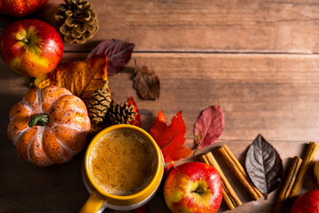 Hot drink, cosy autumn coffee drink, with apples and cinnamon, orange pumpkins, wooden rustic background
