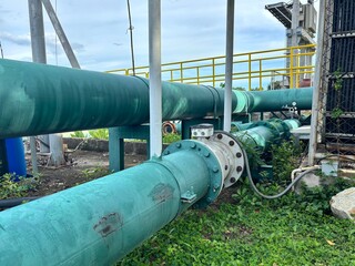 An industrial pipe network is shown in the image, featuring a flow meter connected with flanges....
