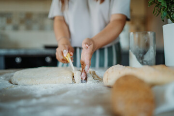 Young caucasian woman making bread dough with rolling pin and flour	
