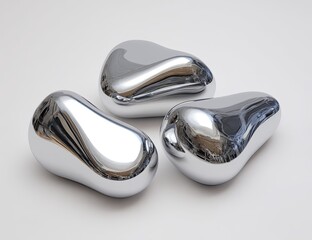Three smooth, reflective, metallic ovals on a light gray background.  