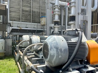 An industrial-grade water pump and its electric motor sit on a sturdy metal base, connected to...