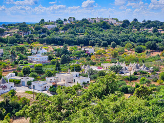 Fototapeta premium Village on the side of the mountain surrounded by trees. Aerial drone photo. View of hebden bridge showing streets and the town centre surrounded by pennine countryside in summer sunlight.