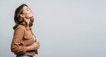 Happy young woman smiling with eyes closed in profile. Portrait of a content person feeling relief and freedom. Studio shot with copy space