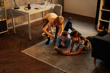 Gen Z children using tablet together in their bedroom