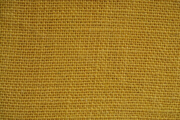 Yellow burlap fabric texture – close-up background top view 