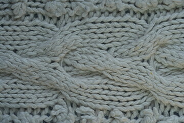 light blue texture of knitted wool silk fabric as a background, blue smooth symmetrical lines of hand-knitted needlework pattern	
