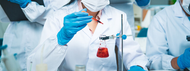 Scientists conduct a medical experiment with blood samples in a laboratory flask, highlighting...