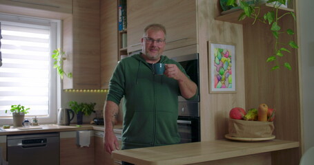 Man reacting to hot beverage, tasting coffee or tea, moment of reflection, casual kitchen setting,...