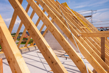Auf dem Neubau von einem Wohnhaus wird mit Dachbalken ein neuer Dachstuhl montiert, als Symbolbild für Wohnbau und Wohnungspolitik