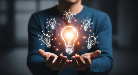 Man holding glowing light bulb in hands surrounded by other light bulbs, symbolizing innovation, creativity, and new ideas