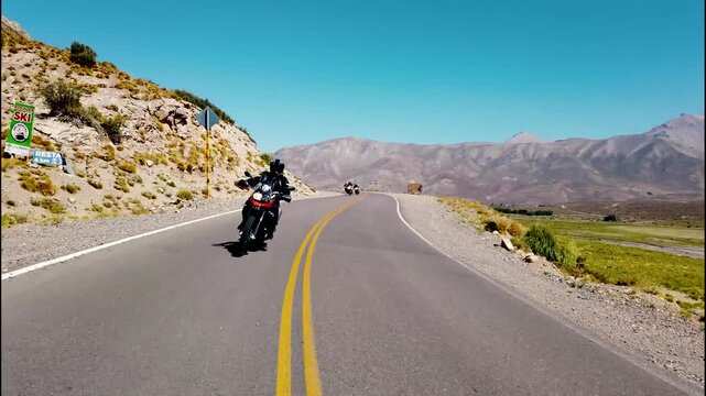 Pilotos de motocicleta transitan ruta en dia de verano.
