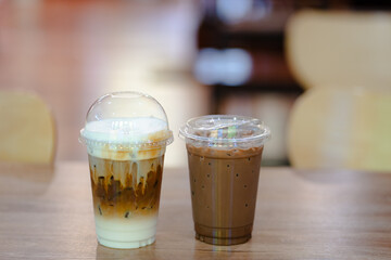 Close up glass of ice latte and ice chocolate on black marble table of a coffee shop summer terrace, menu photography.