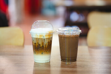 Close up glass of ice latte and ice chocolate on black marble table of a coffee shop summer terrace, menu photography.