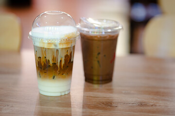 Close up glass of ice latte and ice chocolate on black marble table of a coffee shop summer terrace, menu photography.