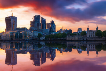 London skyline with reflection from river Thames against a dramatic sunset sky 