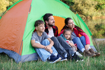 Happy family spending time together with camping tent outdoors