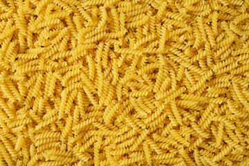Raw Italian pasta in the background. Pasta in the form of a spiral